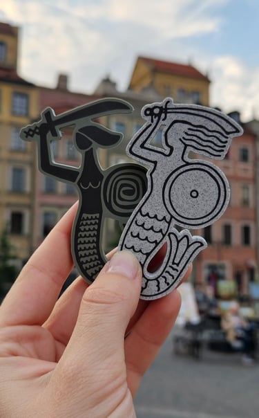 Dwie syrenki na tle rynku Starego Miasta w Warszawie