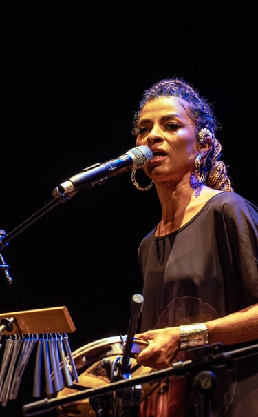 Cantora com um pandeiro na mão e microfone