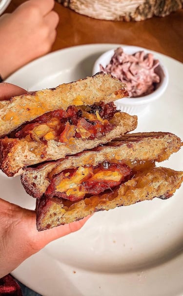 onion bhaji and mango chutney toastie held by customer at the ark vegan cafe