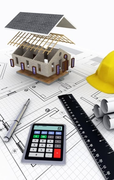 éléments pour faire un devis travaux, calculatrice, règle, plans, stylo et maquette maison