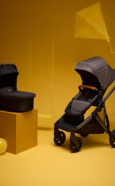 Product campaign photography - a baby stroller and a baby carrier on a yellow background
