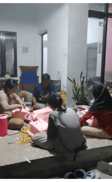 Community artisans handweaving plastic woven bags together in a home production setting at Craftvitas Indonesia.
