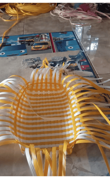 Base structure of a handmade woven bag using natural colored recycled plastic strips at Craftvitas Indonesia.