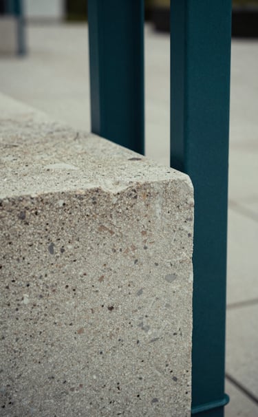 Macro photography of weathered stone and modern steel interfaces in a public plaza. The palette consists of soft sage and deep sea teal shadows. Professional, close-up composition.