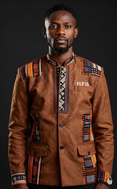 A powerful studio portrait of P.E.P YLS wearing a custom-tailored jacket in #3D2C20 brown, blending Nigerian textile patterns with modern streetwear silhouettes. The background is a clean #0A0A0A, and the lighting is sharp, emphasizing his confident expression and regal posture.