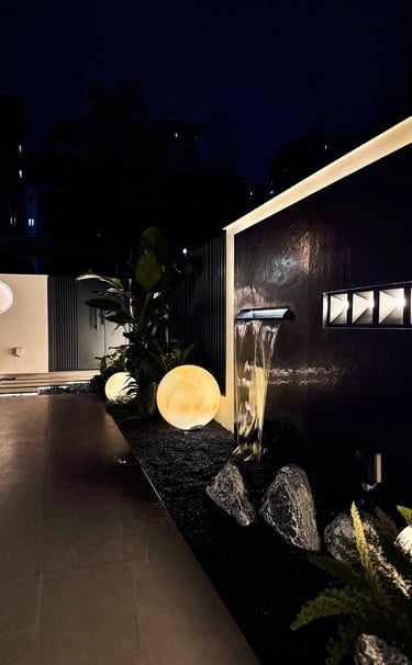 Elegant garden water wall with decorative lighting and natural stone.