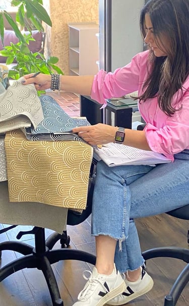 Sigal, founder of Solo Home Decor, selects fabrics while designing custom furniture.