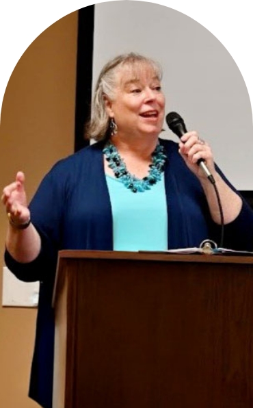 Debbie Chen speaking at a podium with a microphone, business leadership coach and speaker.