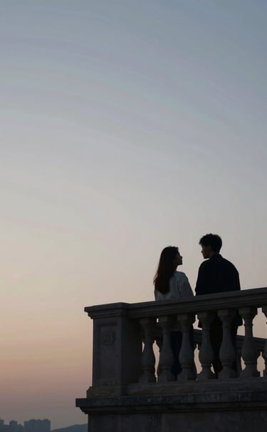 A wide cinematic still of a couple sharing a quiet moment on a stone balcony at dusk. Deep #20232B shadows contrast with a soft #F7F5F0 sky. Artistic lighting with a contemporary, high-fashion flair.