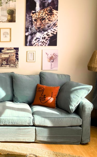 Coin salon cosy avec canapé bleu et déco murale dans hébergement professionnel.