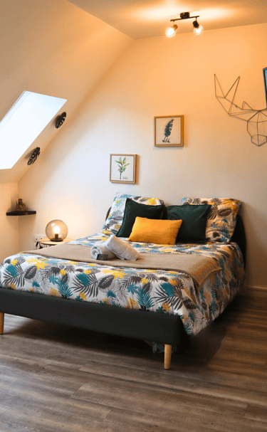 Chambre confortable sous combles avec lit double, idéale pour séjour d’un voyageur seul.