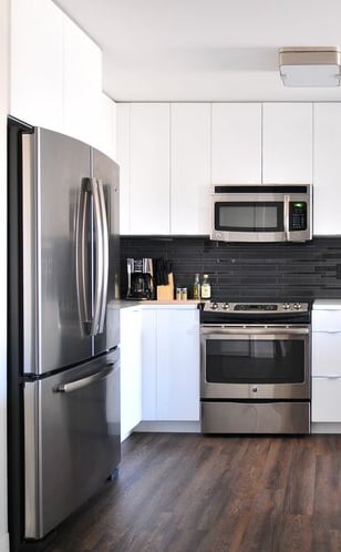 a kitchen with a refrigerator, microwave, and a microwave