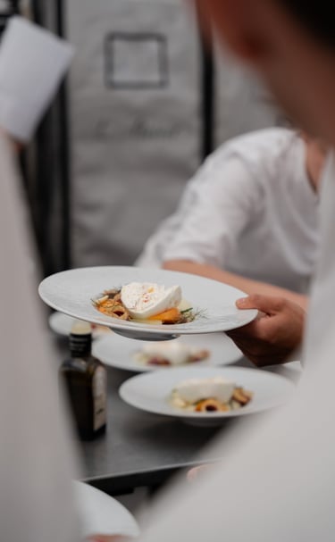 Assiette dressée tenue dans une main d'un cuisiner