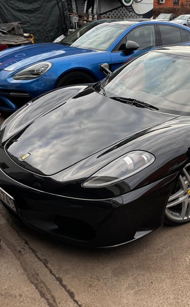 an Enlab black Ferrari car parked in a parking lot