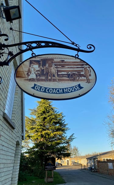Cast iron pub sign with painting depicting former brewery staff