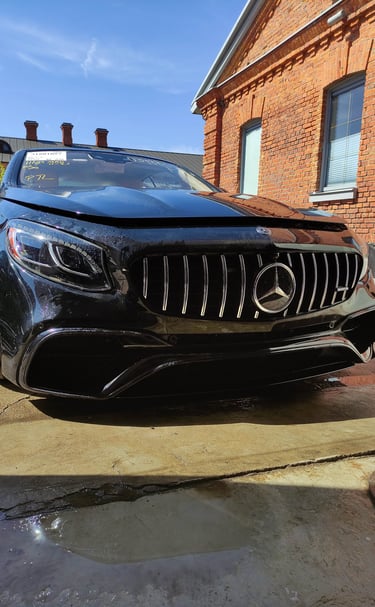 an Enlab Mercedes car parked in a driveway with a car in the background