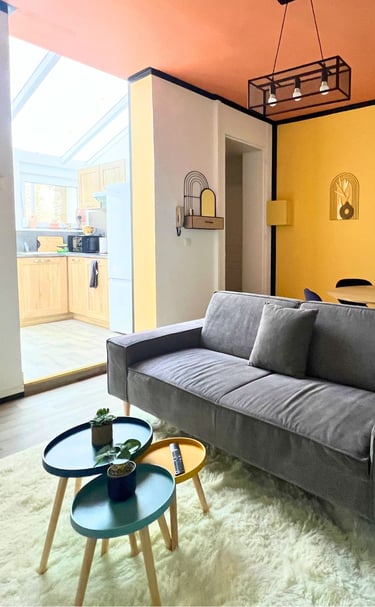 Salon lumineux avec canapé et cuisine équipée pour voyageur seul en déplacement.