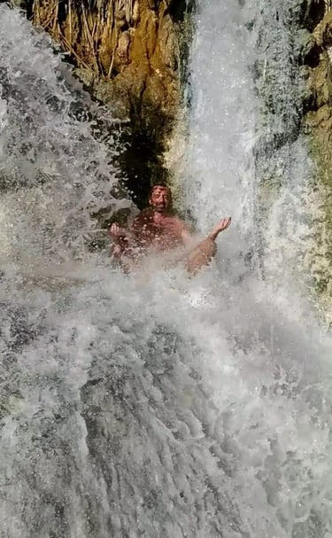a man meditating in a waterfall in the middle of a waterfall