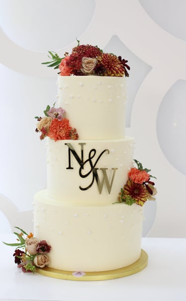 Tarta de boda personalizada de tres pisos con flores naturales, elaborada artesanalmente en Madrid