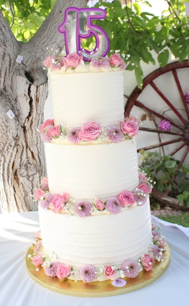 Tarta de cumpleaños elegante con flores naturales en tonos rosas, creada en Madrid
