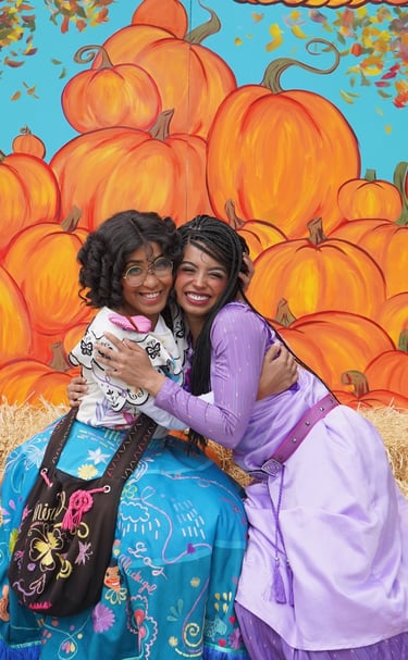 Mirabel and Asha hug for a photo at a fall festival
