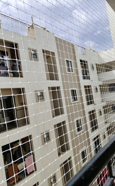 Close-up of a tightly woven safety net installed on a balcony railing.