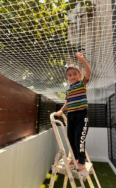 Technician from Arjilli Enterprises installing pigeon nets carefully on a residential balcony