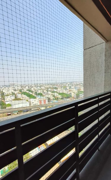 Close-up of sleek white pigeon nets installed on a sunny Whitefield balcony.