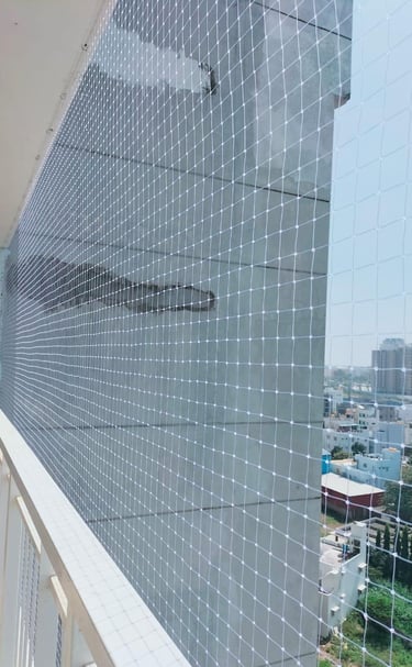 Technician from Arjilli Enterprises carefully fitting a safety net on a rooftop edge.