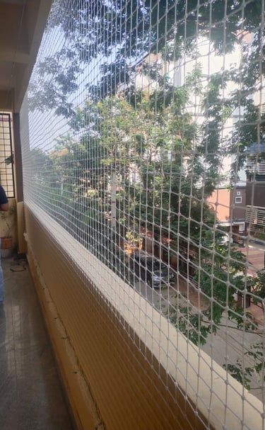Evening view of a balcony with safety net installation glowing softly under warm lights.