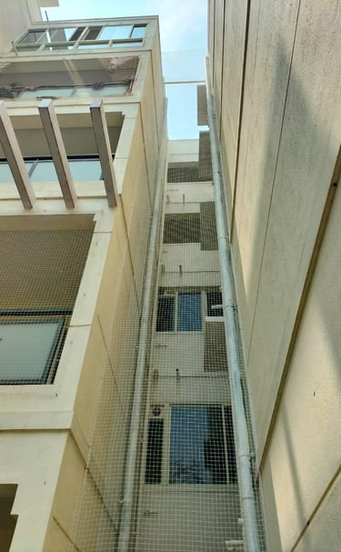 Close-up of a tightly secured duct area net preventing pigeons from entering an apartment balcony.