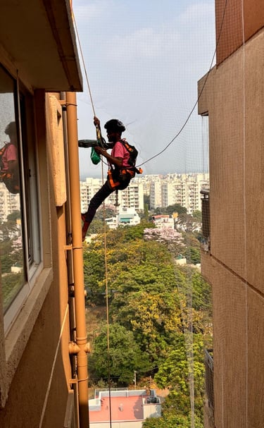 Installation team from Arjilli Enterprises fitting pigeon nets on a spacious terrace.