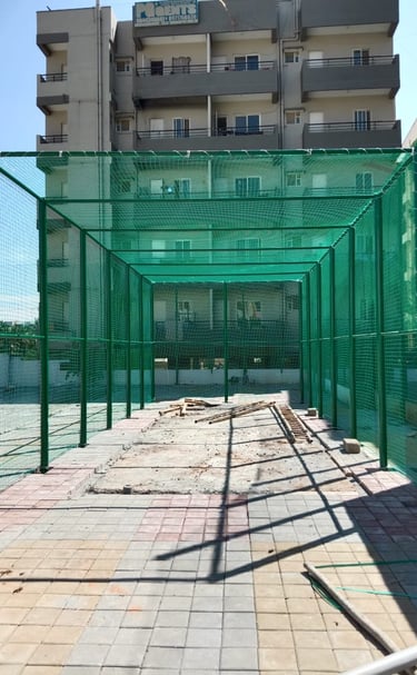 Wide shot of a football net setup on a rooftop with cityscape background.