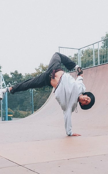 YoYo performing a breakdance freeze in a skateboard park.