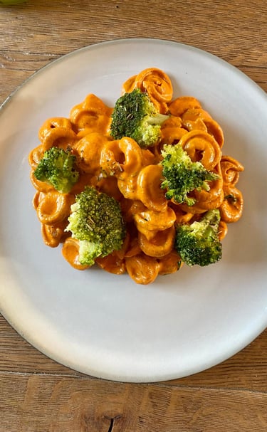 a plate of pasta with broccoli and cheese