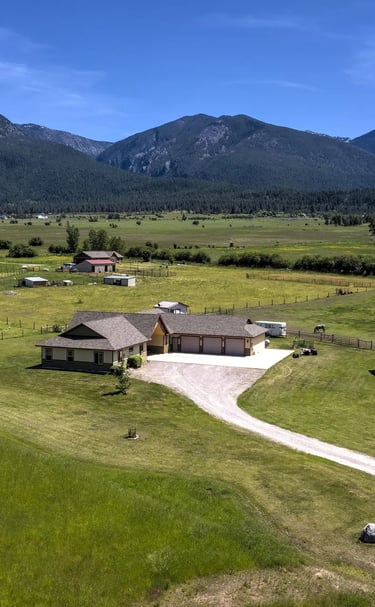 Aerial view of custom home with Montana's Mission Mountains in the background by Saddlle Horn