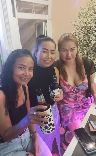 three women sitting at a table with drinks