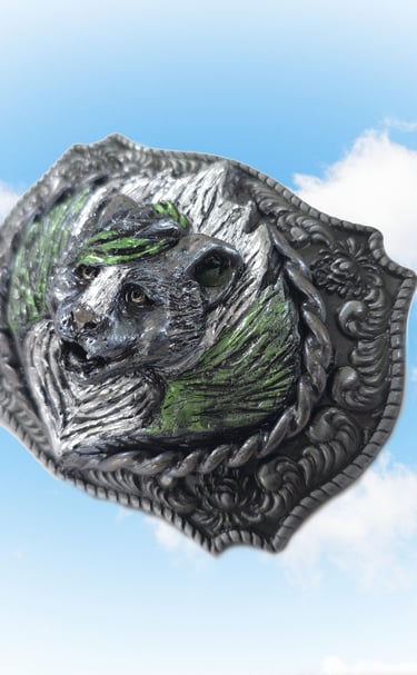 Vintage silver western belt buckle featuring a detailed skunk design against a blue sky background.