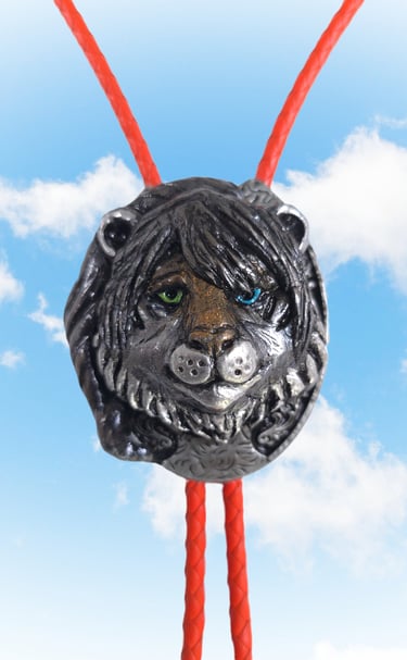 Handmade vintage style silver lion bolo tie with green and blue eyes on a red braided leather cord