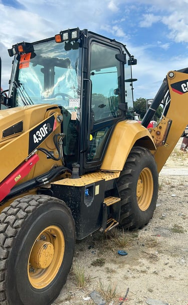 a yellow backhoeck tractor with a large wheel