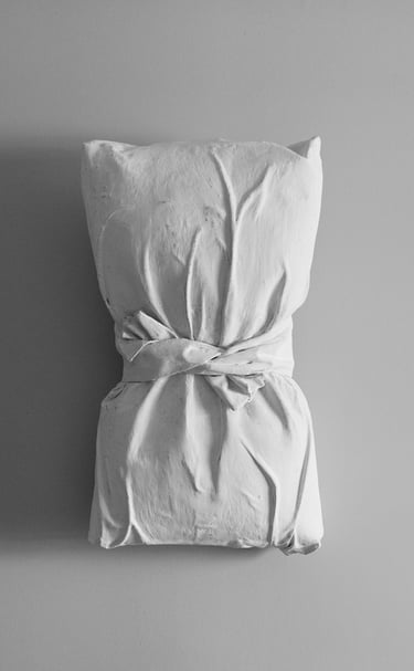 A pillow that is wrapped in plastered fabric
