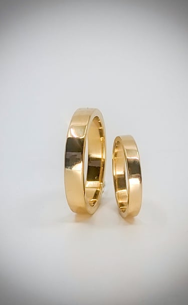a Pair of classic 18kt gold hsi and hers wedding bands