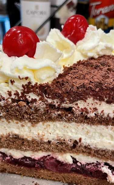 a piece of Black Forest cake with cherries on top of it