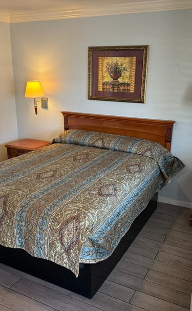 a motel room with a bed and a lamp