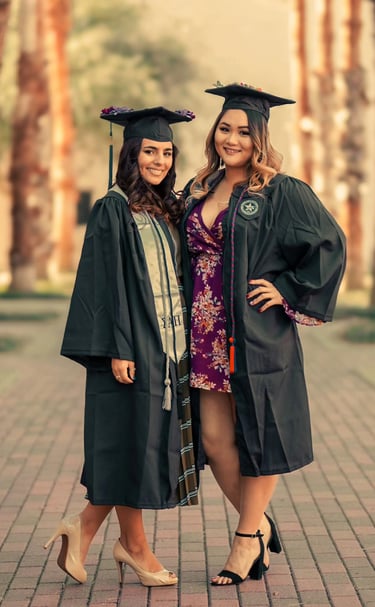 two women in graduation gowns posing for a photo