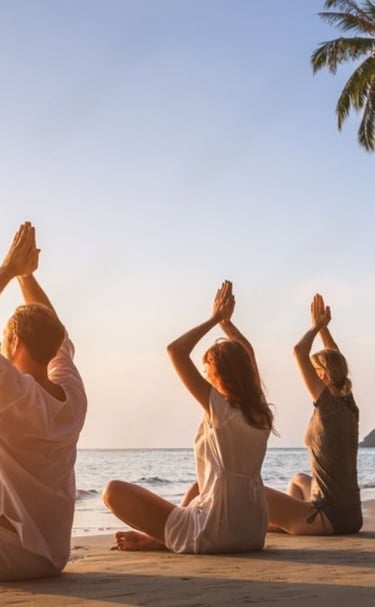 a group of people doing yoga on the beach