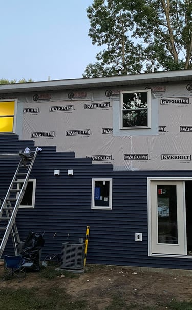 Old siding replacement in process with new durable siding on residential home