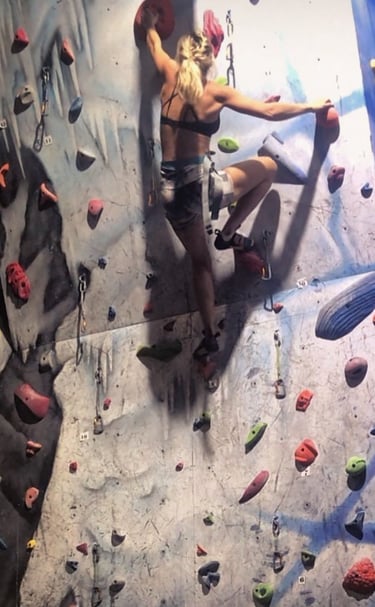 a woman climbing a climbing wall on a climbing wall