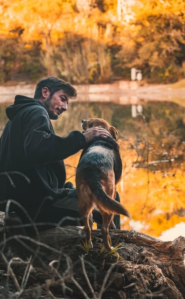 un padrone guarda in modo amorevole il proprio cane sullo sfondo di un lago