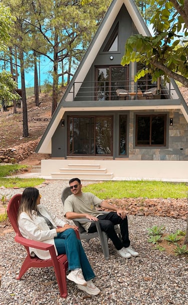 a man and woman sitting on a bench in front of a house